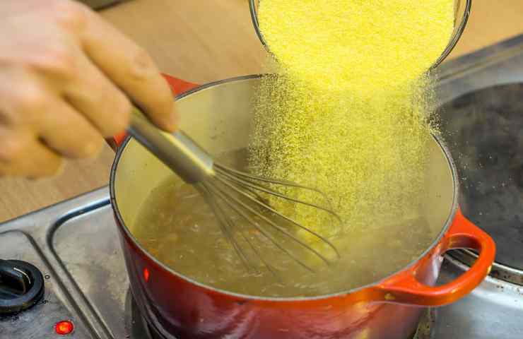 farina di mais versata in acqua bollente salata